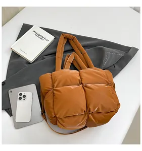 Close-up of quilted caramel brown tote bag with puffy texture for autumn fashion