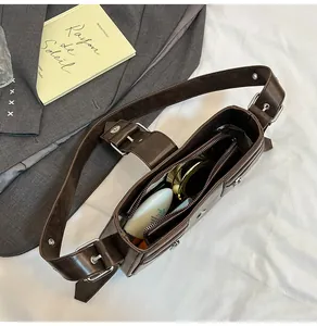 Detaillierte Innenansicht einer dunkelbraunen Ledertasche mit täglichen Utensilien darin
