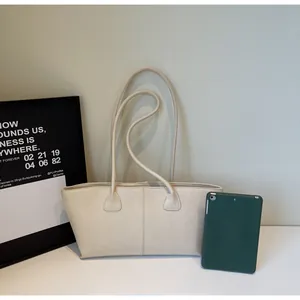 Close-up of cream leather tote bag with tablet showing large capacity and texture