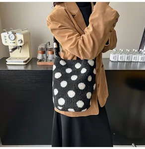 Primer plano de un bolso de felpa con lunares blancos y negros en una cafetería acogedora