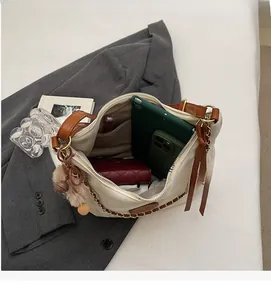 Top view of cream tote bag interior showing large capacity with compartments and gold chain