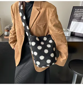 Detalle del bolso de peluche con lunares blancos y negros y correa de hombro cómoda