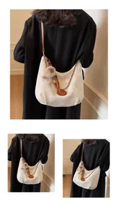 Detail of white crescent tote bag with leather strap and chain for commuter style