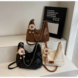 Detailed view of three vintage hobo bags in brown and beige with plush sheep charms