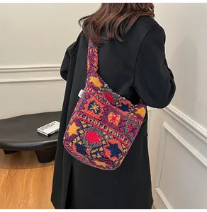 Primer plano del bolso de hombro de felpa con patrón étnico y suave textura de vellón de otoño