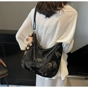 Detail of black marble pattern tote with silver chain and cute lion plush charm
