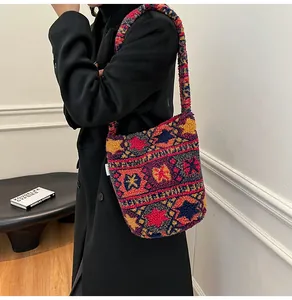 Detalle del bolso tipo cubo de punto bohemio con motivos geométricos sobre tejido de felpa
