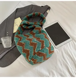 Detalle de patrón de punto en zigzag verde azulado y marrón en un bolso de cubo suave