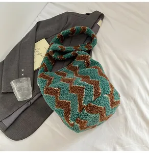 Detalle del bolso de peluche tejido con ondas verdes y marrones y correa suave