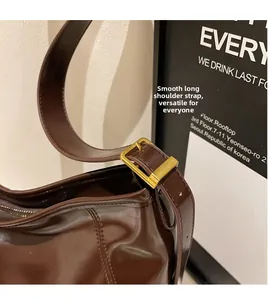 Detail of vintage brown tote featuring smooth shoulder strap and gold square buckle