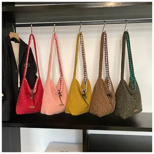 Row of plush Hobo tote bags in five colors with textured fleece and drawstring details