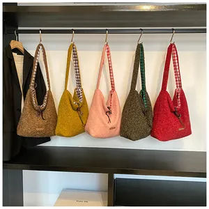Detail of plush Sherpa tote bags in various colors with check lining and drawstring