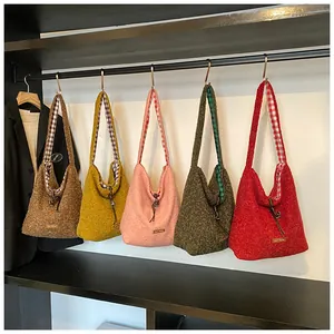 Detail of colorful plush tote bags with plaid strap lining and decorative charms