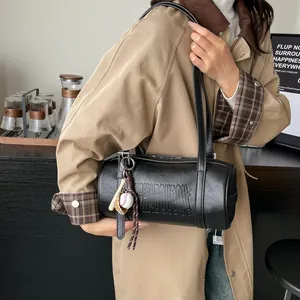Minimalistische schwarze Zylindertasche mit Vintage-Prägung und Baseball-Anhänger