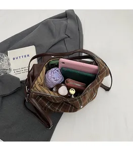 Top view of spacious plaid tote bag interior with multiple everyday items stored inside