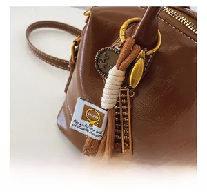 Detail shot of the vintage brown leather handbag with decorative golden star and woven charms