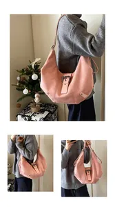Detail view of pink suede hobo bag with vintage metal buckle and adjustable shoulder strap