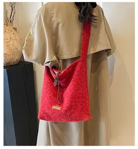 Detail of red plush tote bag showing the texture, drawstring closure, and star charm