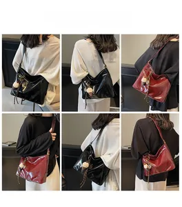 Detail view of large tote bag in black and burgundy with plush charm and side profile