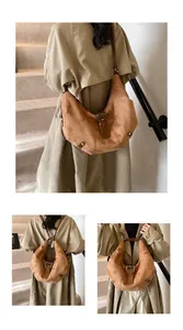 Detail of a brown suede half-moon shoulder bag with adjustable straps and silver hardware