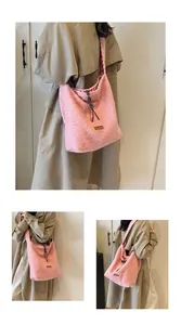 Detailed macro view of pink plush tote bag with brown leather label and plaid lining