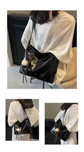 Detail view of large black glossy tote bag featuring a cute plush ice cream keychain