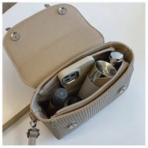 Interior view of beige leather crossbody bag showing capacity for phone and cosmetics