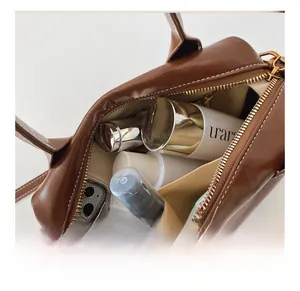 Top view of the spacious interior of this dark brown leather handbag with bronze zippers