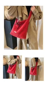 Detail of red plush tote bag with drawstring closure and decorative textile label
