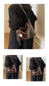 Detail of a dark brown large shoulder bag in glossy leather with plush ice cream charm