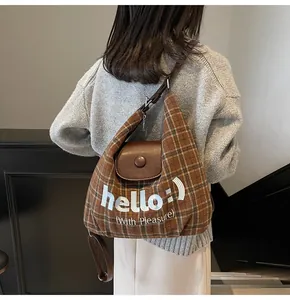 Brown checkered shoulder bag with embroidered 'hello' text and leather flap detail