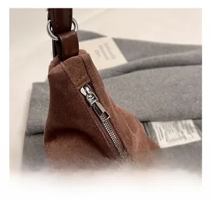 Detail of premium silver zipper and metallic hardware on coffee suede shoulder bag