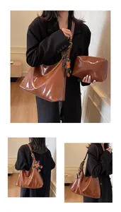 Polished brown faux leather tote bag with small matching pouch and bear pendant detail