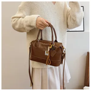 Detail of dark brown vintage Boston bag with abacus charm and white brand label