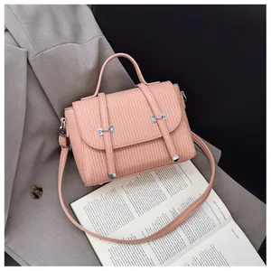Detailed macro view of the pink lychee leather texture and silver buckle on the handbag