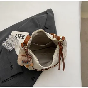 Detail view of large tote bag interior with side pocket and chain shoulder strap