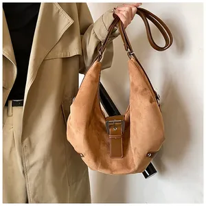 Macro detail of camel oversized hobo bag showing brushed suede texture and metal buckle