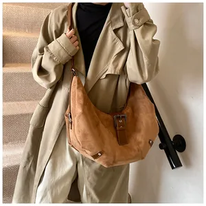 Detail of the caramel suede hobo bag featuring premium texture and vintage metal buckle