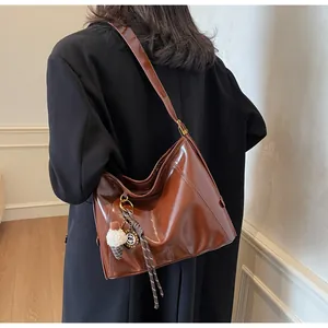 Brown leather tote bag back view with ice cream charm and glossy finish