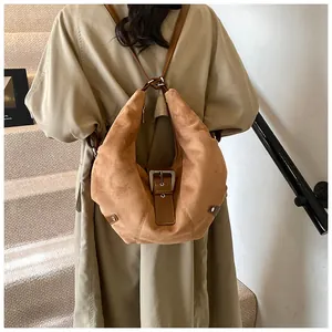 Close-up of retro brown suede backpack with vintage metal buckle and matte texture