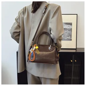Detail of vintage brown leather doctor bag with yellow tag and metal abacus charm