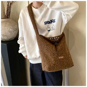 Detail of plush brown shearling tote bag featuring drawstring closure and inner plaid lining