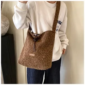 Detail of a brown plush tote bag with drawstring closure and soft fleece texture