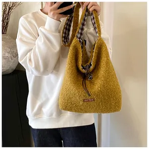 Close-up of mustard yellow plush tote bag with cozy fleece texture and brand label