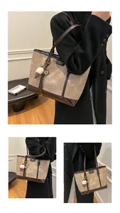 Détail d'un grand cabas en toile avec garniture en cuir marron et breloque peluche