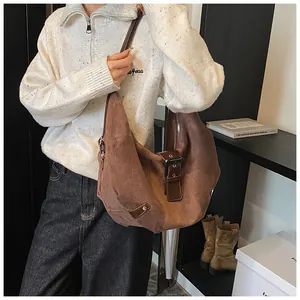 Detailed macro view of deep coffee matte leather shoulder bag with metallic buckle detail
