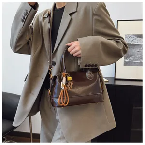 Detailed view of dark brown oil wax leather pillow bag with vintage abacus charm
