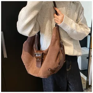 Detail of dark brown matte hobo bag with vintage metal buckle and crescent pleat design