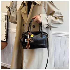 Detail of black vintage Boston bag with gold lock charms and woven strap accents