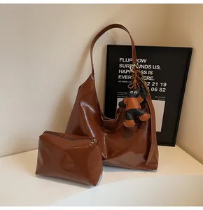 Detail of dark brown glossy hobo bag set with matching pouch and cartoon cat charm